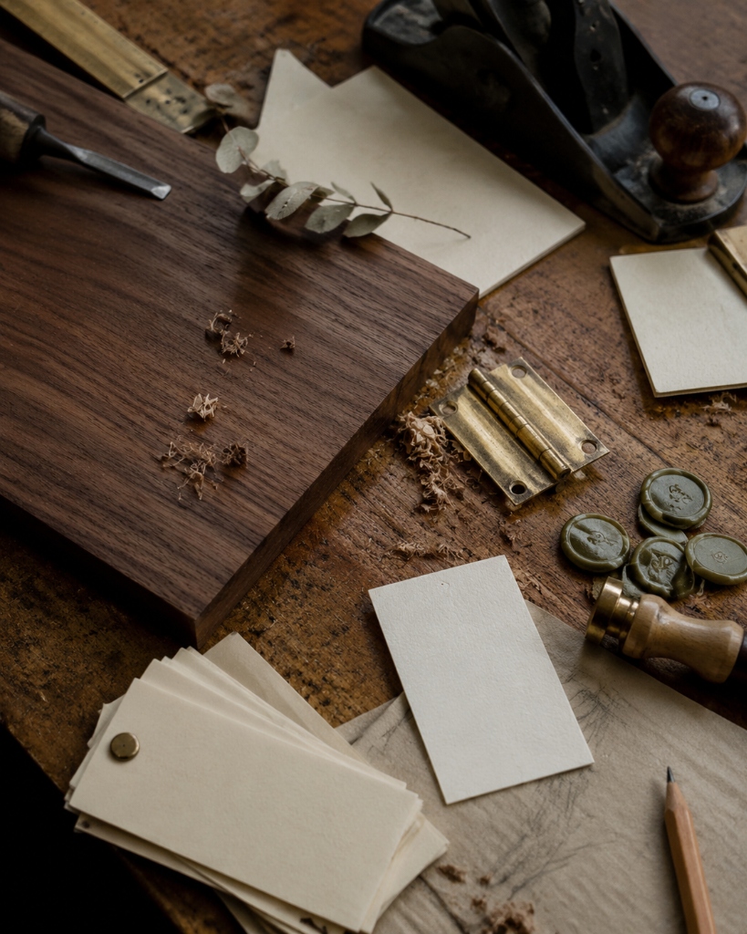 Atelier de Presente: madera de nogal noble, herrajes de latón envejecido, papel de algodón, sellos de lacre botánicos y gubias artesanales